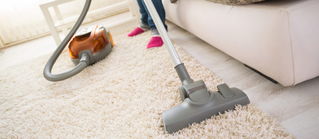 person vacuuming a carpet