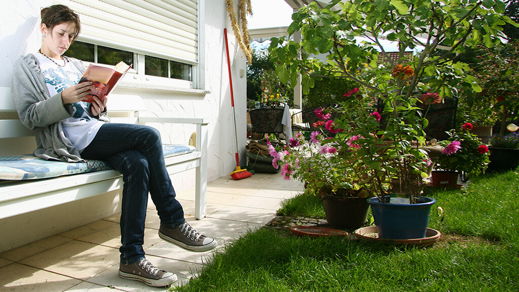 person reading book in garden
